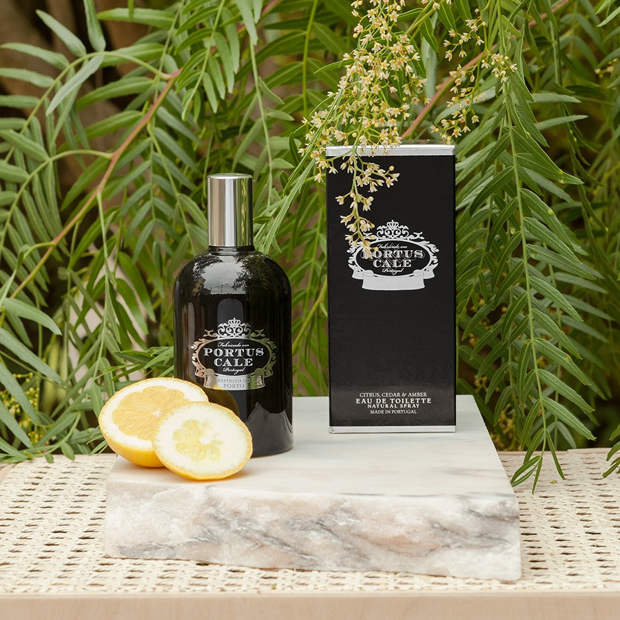 Portus_Cale_Black_Eau_de_Toillette_Castelbel on a marble block with a garden in the background