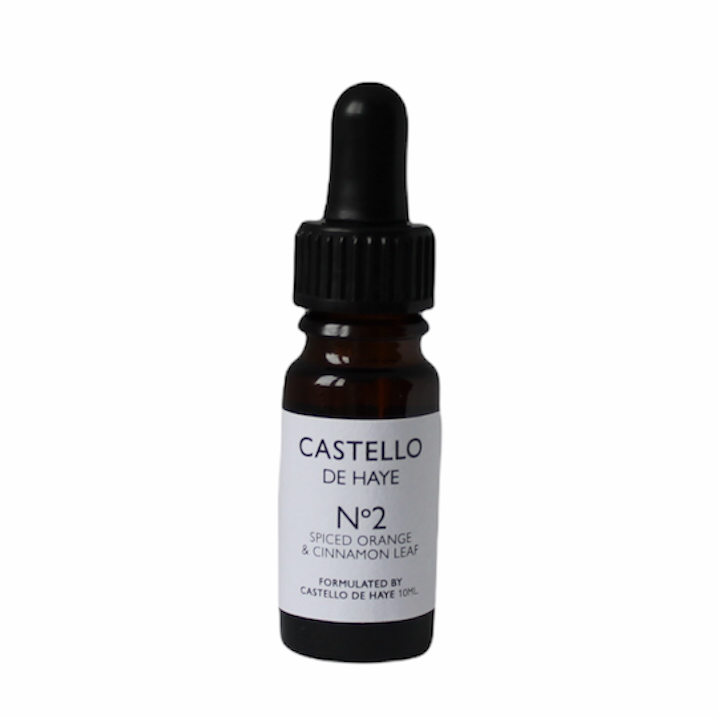 A 10ml amber glass bottle with a black dropper labeled 'Castello de Haye No.2 Spiced Orange & Cinnamon Leaf Essential Oil.'