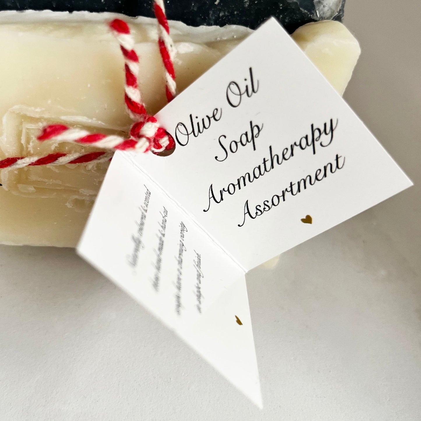 Olive Oil Soap Aromatherapy assortment label tied by twine to a mixed bundle of soap