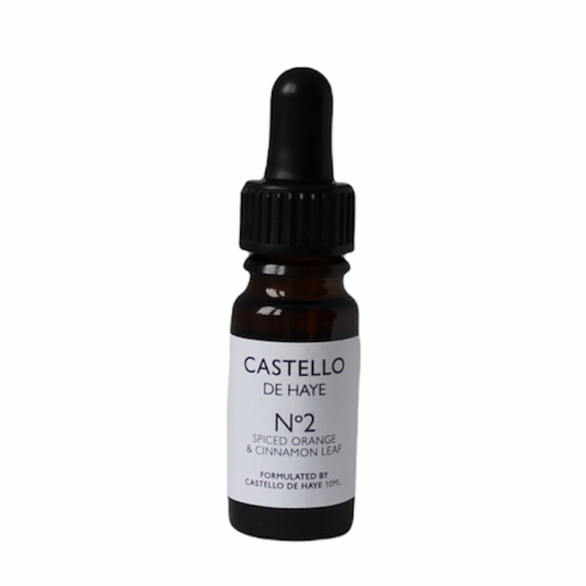 A 10ml amber glass bottle with a black dropper labeled 'Castello de Haye No.2 Spiced Orange & Cinnamon Leaf Essential Oil.'